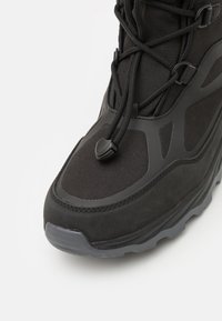 Czarne buty trekkingowe z teksturowanego materiału, gumową podeszwą i regulowanym systemem sznurowania, zapewniającym pewne dopasowanie. Lekka i trwała konstrukcja.
