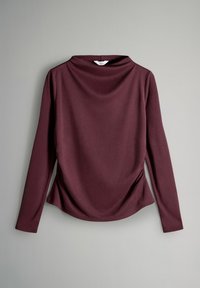 Halenka s dlhým rukávom v hlbokej burgundy, vyrobená z mäkkej tkaniny. Obsahuje okrúhly výstrih a zhrnutie na boku pre zvýšenie textúry.