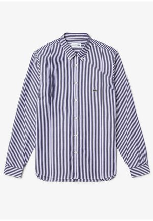 Camisa de manga larga a rayas azul y blanca con cuello abotonado y un pequeño logo verde en el pecho. Tejido de algodón, textura suave.
