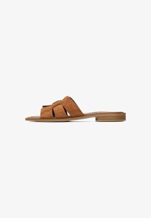 Sandalia cómoda de ante marrón con diseño de tiras cruzadas anchas, suela plana y accesorios mínimos. Textura suave en toda la superficie.