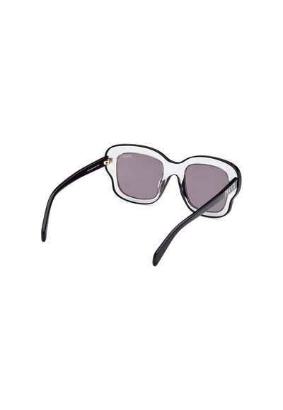Gafas de sol negras y transparentes de gran tamaño con lentes de color púrpura claro, con un diseño de montura ondulante y un acento dorado en la bisagra.