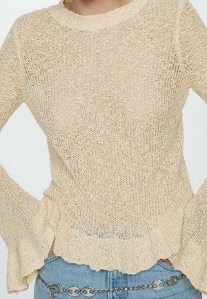 Pull en maille de couleur beige clair avec des manches longues évasées et un ourlet à volants. Présente une texture à trame ouverte et un col rond.