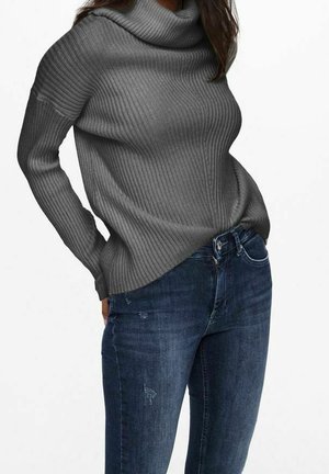 Maglione grigio a coste con collo a barchetta, dotato di maniche lunghe e vestibilità comoda, abbinato a jeans scuri con strappi.