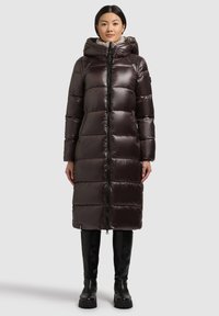 Langer, voluminöser dunkelbrauner Daunenmantel mit Reißverschluss, hohem Kragen und Kapuze. Glattes, glänzendes Material mit markanten Nähten und seitlichen Taschen.