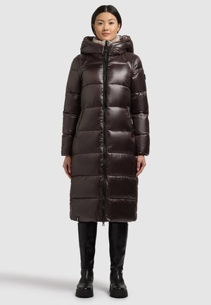 Lång, puffig mörkbrun dunjacka med dragkedja, hög krage och huva. Slät, glansig tyg med framträdande sömmar och sidofickor.