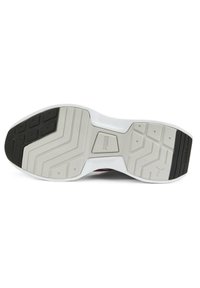 Semelle de chaussure en caoutchouc présentant un motif texturé mêlant noir et blanc. Comprend des rainures prononcées et un détail de logo.