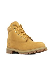 Bota de senderismo de cuero marrón claro con punta redonda, parte delantera con cordones, ojales dorados y panel trasero texturizado. Presenta una suela de goma resistente para mayor tracción.