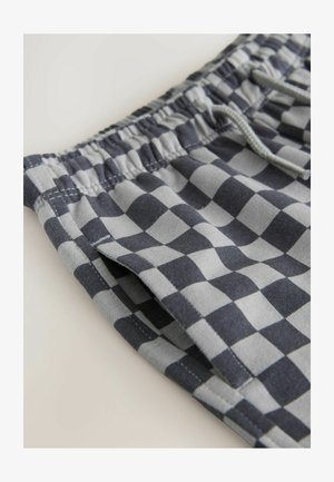 Shorts gris et noirs à carreaux avec une ceinture élastique et un cordon de serrage. Comprend des poches latérales et un tissu en coton doux.