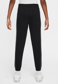 Black sweatpants with a slim fit, elastic waistband, and side striping detail. Soft fabric and ribbed cuffs create a comfortable fit.