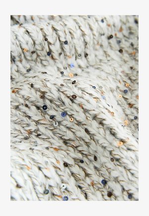 Dikke, gebreide stof in het wit met bruine spikkels. Ingebedde pailletten in goud, brons en blauw voegen textuur en visuele belangstelling toe.