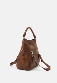 Sac à main en cuir marron avec visages de Mickey Mouse embossés, poignée tressée, poche zippée à l'avant et bandoulière réglable sur fond blanc.