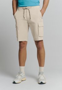 Beige cargoshorts met zijzakken, elastische tailleband en trekkoord. Gemaakt van lichtgewicht stof, geschikt voor casual wear.