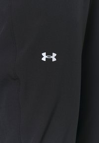 Svarta träningsbyxor med en slät yta, med en liten vit Under Armour-logotyp på sidan och rena sömdetaljer.