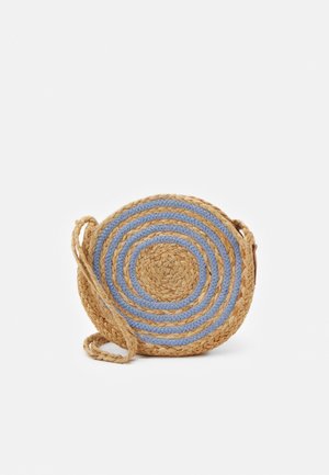 Round crossbody bag made of woven straw with alternating tan and blue circular patterns. Features a braided strap and textured surface.
