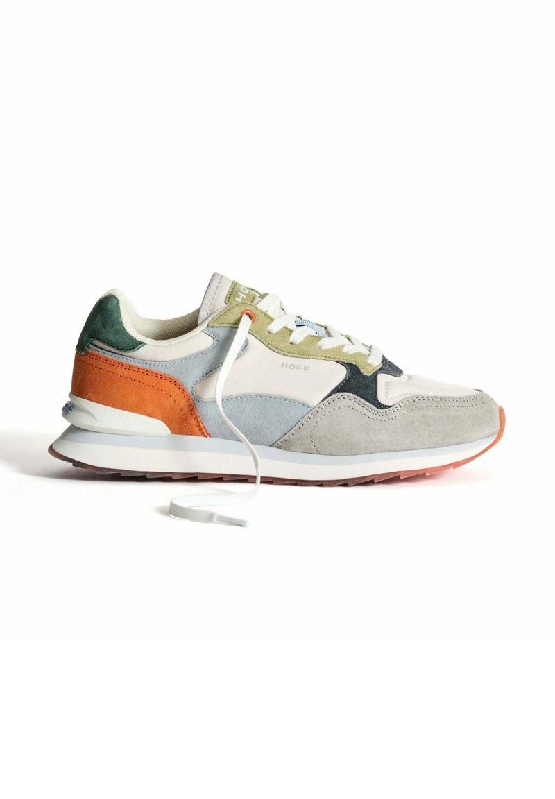 Zapatilla ligera que presenta una combinación de ante gris, verde y naranja. Punta redondeada, cordones blancos y suela de goma con acentos texturizados.