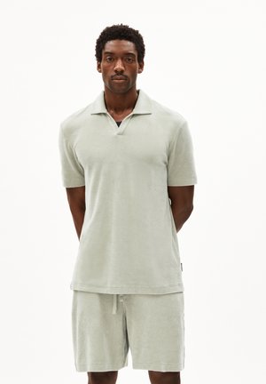 Lichtgroene badstof polo shirt met korte mouwen, voorzien van een kraag en bijpassende shorts. Zachte textuur en een relaxte pasvorm.
