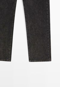 Pantaloni in denim neri con una finitura leggermente sbiadita, taglio dritto con cuciture visibili lungo le cuciture e un orlo pulito.