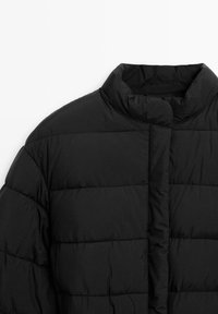 Black quilted puffer jacket with high stand collar and horizontal stitching, photographed on a white background.