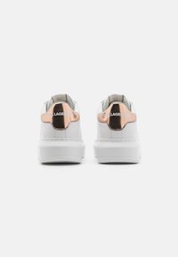White leather sneaker with a chunky sole, metallic rose gold accents on the heel, and embossed logo detail on the back panel.