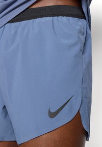 Σορτς αθλητικά Nike σε ανοιχτό μπλε ύφασμα με μαύρη μέση. Διαθέτει μαύρο λογότυπο στο πλάι και διακριτές λεπτομέρειες εξαερισμού.