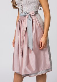 Traditionelles Dirndl mit einer grauen Satinschleife in der Taille, einem strukturierten pinken Satinflair und einem kunstvoll gemusterten Mieder.