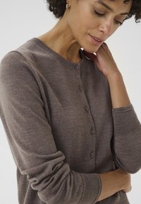 Brown knit cardigan featuring a round neckline, button closures, and ribbed cuffs. Soft texture with a fitted design.