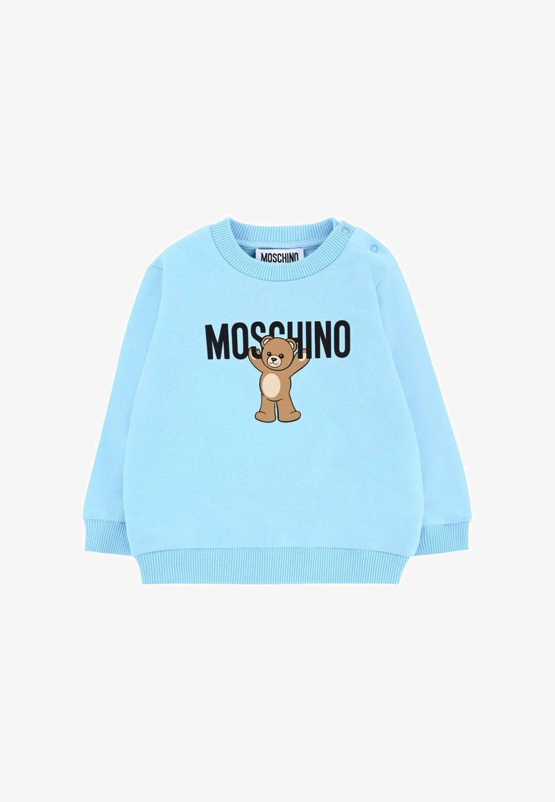 Felpa azzurra chiara in cotone, decorata con una grafica di un orso e il logo "MOSCHINO" in grassetto nero. Include un colletto e polsini a costine.