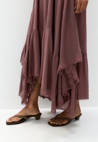 Robe longue et fluide en rose pastel avec un ourlet effiloché et des volants superposés. Portez-la avec des sandales marron à petit talon et avec une quincaillerie décorative.