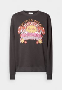 Sudadera gris oscuro con cuello redondo y mangas raglán. Presenta un gráfico colorido de un sol, hongos y flores con el texto "Despierta con la armonía del sol."