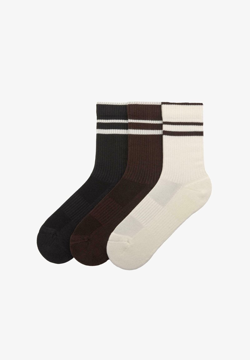 Drei Paar Socken in Schwarz, Braun und Creme. Jede Socke weist eine gerippte Struktur und einen kontrastierenden weißen Streifen nahe der Oberseite auf.