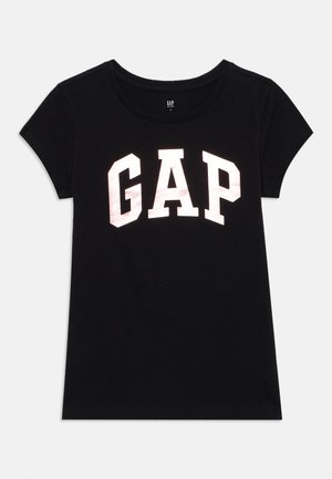 Must musta T-särk lühikeste varrukatega ja ümarate kaelustega, mille esiküljel on suur valge "GAP" logo julges, plokikirjas.