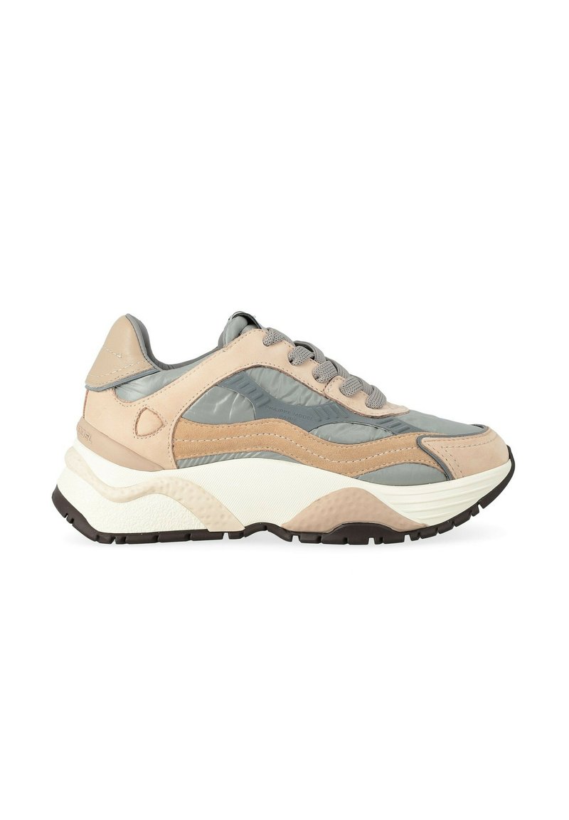 Baskets de sport beige et grise avec semelle texturée, col rembourré et fermeture à lacets, conçues pour un usage décontracté et sportif.