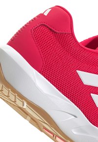 Felroze sportschoen met een bovenwerk van mesh, witte accenten en een getextureerde rubberen zool met een gouden tint. Inclusief logo-opdruk aan de zijkant.