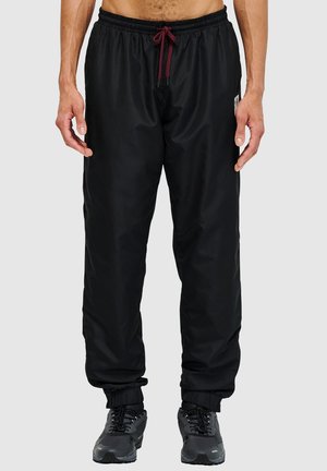 Zwarte, lichtgewicht broek met elastische taille en bordeauxrode trekkoord en elastische boorden. Ontworpen met een zijlabel en een zachte textuur.
