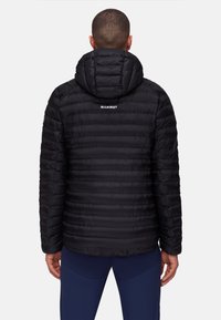 Black insulated jacket with a hood, featuring a quilted design and the brand name "MAMMUT" printed on the back. Smooth texture.
