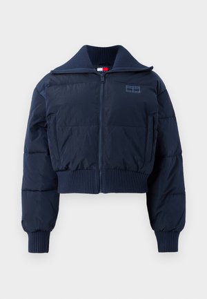 Marineblauer verkürzter Pufferjacke mit hohem Kragen, Reißverschluss, gerippten Bündchen und einem dezenten Logo-Patch auf der Brust. Glatte, matte Stoffstruktur.