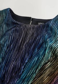 Abito plissettato metallico con scollo rotondo, in gradiente di blu a oro, e una zip nascosta sul retro. Il tessuto ha una consistenza liscia.