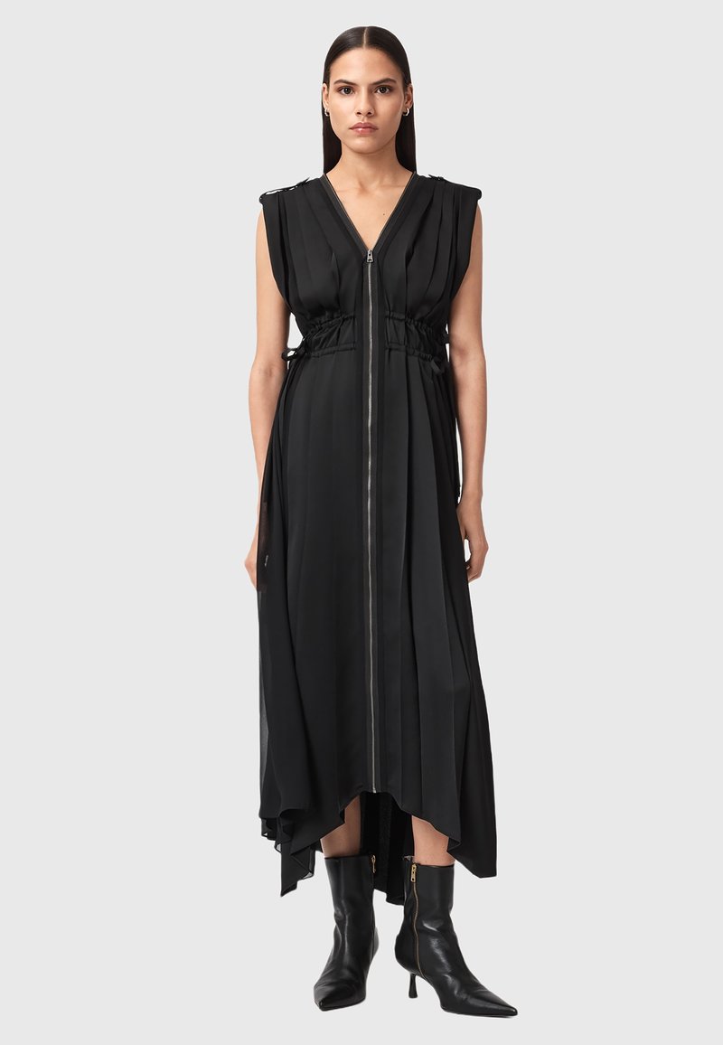 Vestito nero senza maniche con cerniera frontale, vita stretta e orlo asimmetrico. Realizzato in tessuto liscio con pieghe sottili e hardware minimale.