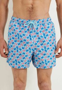 Costumi da bagno con uno sfondo azzurro e un motivo di granchi blu e rosa. Fascia elastica in vita con un cordoncino azzurro.