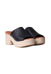Black leather mules with an open toe design, featuring a braided jute platform heel and a smooth tan insole.