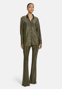 Metallisch olijfgroene, langarm blouse met knopen, gecombineerd met vloeiende broek, beide met een gladde textuur en een klassieke kraag.
