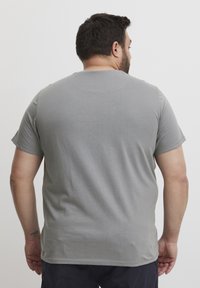 Grijs katoenen t-shirt met korte mouwen, ronde halslijn en een gladde textuur. Heeft een eenvoudig ontwerp zonder versieringen.