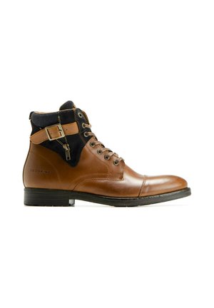 Bottine en cuir marron avec col en tissu noir, boucle latérale et fermeture éclair, laçage sur le devant et semelle basse noire.