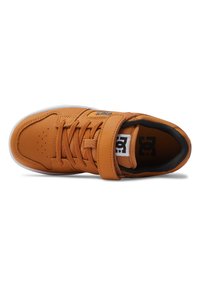 Botte de skate en cuir orange avec semelle en caoutchouc blanche, dotée de lacets et d'une sangle Velcro. Comprend des perforations et un détail de logo sur le côté.