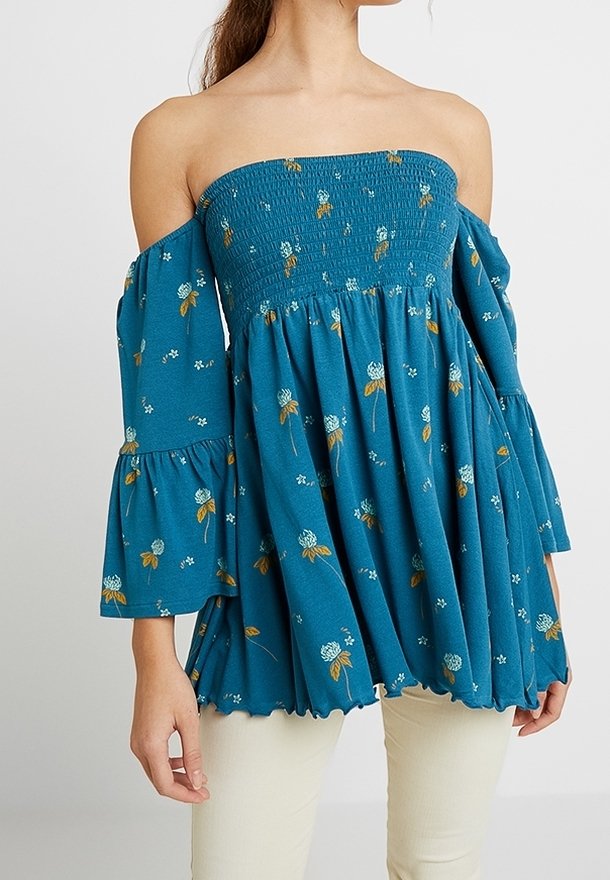 Turkoosi olkapäät paljastava yläosa, kevyt kangas, jossa on kerrostettua rypytystä, kellohihat ja valkoisilla ja keltaisilla korostuksilla koristeltu kukkakuvio.