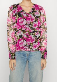 Blusa trasparente a maniche lunghe con scollatura a V, motivo floreale vivace in rosa su sfondo nero, con dettagli a bottoni sulle maniche.