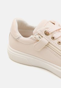 Kerge roosa sneaker, millel on sile nahk peal, sama tooni õmblused, kullatoonilised detailid ja valge kummist tallad. Varustatud lukksepalise sulgemisega.