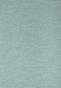 Lichtblauw geribd breisel, met een fijne textuur van verticale lijnen en een gladde afwerking, geschikt voor kleding of accessoires.