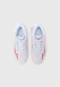 Λευκά αθλητικά παπούτσια με επάνω μέρος από δίχτυ, διακοσμημένα με κόκκινες λεπτομέρειες και υφή με μοτίβο. Τα κορδόνια είναι λευκά· οι εσωτερικές σόλες είναι ανοιχτό γαλάζιες με το λογότυπο.