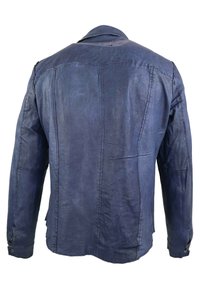 Blå denimjacka med en strukturerad krage, långa ärmar, synliga sömmar och en något texturerad yta.